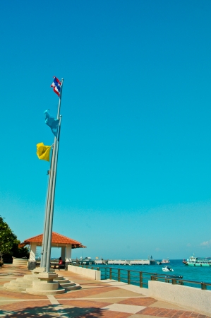 the flag pole beside sea on blue sky backgroundの写真素材
