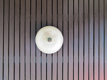 old ceiling lamp on brown wood pattern with sunshineの写真素材