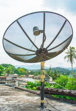 old one black Satellite dish on blue sky at rooftopの写真素材