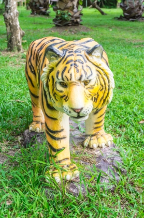 front view tiger statue on nature grass backgroundsの写真素材