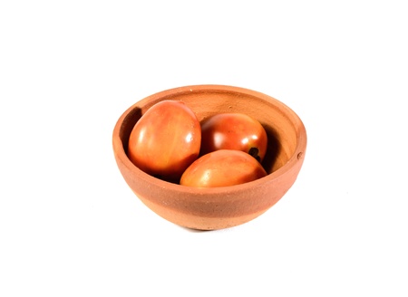 three tomato in bake clay bowl isolated on white backgroundの写真素材