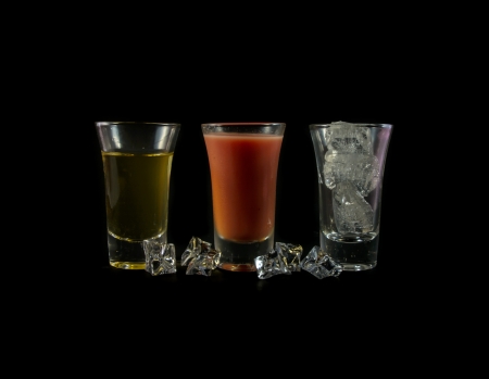 water melon and yellow water drink with ice cube in small glass isolated on black backgroundの写真素材