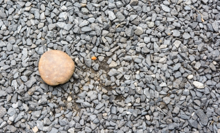single big brown stone on little granite stone ground pattern detailの写真素材