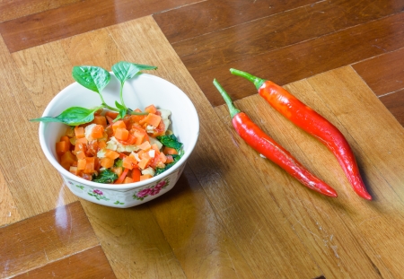 white small mushroom and vegetable fried with red pepper on brown paquet floor groundの写真素材