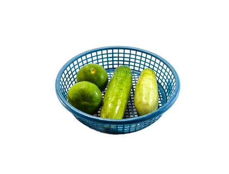 green cucumber vegetable with lemon in small blue basket and shadow isolated on white backgroundの写真素材