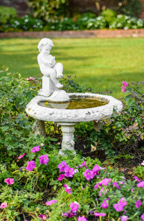 old small child cupid fountain on outdoor natural garden