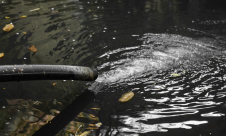 old flow water Drain pipe in grunge small lake