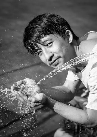 asia young man washing him face and Water splash  with retro filter at blur outdoorの写真素材