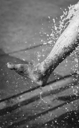 man wash foot and leg with water splash with retro filter at sunrise outdoor backgroundの写真素材
