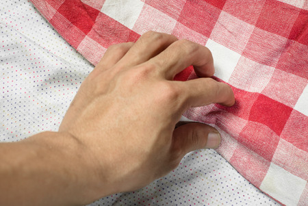 young man hand touching cotton and fabric plaid for backgroundの写真素材