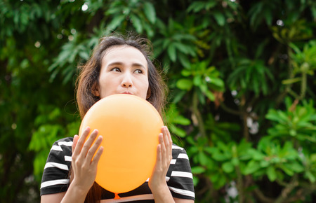 asia young girl hold color balloon at blur outdoor backgroundの写真素材