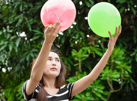 asia young girl play colorful balloon at blur outdoor backgroundの写真素材