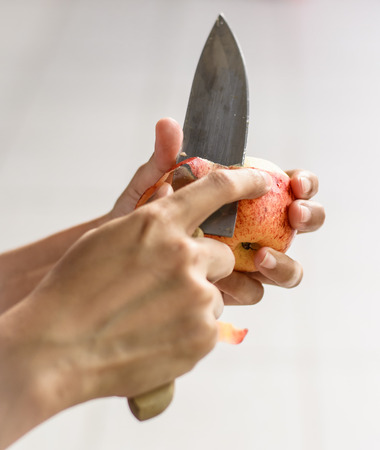 asia woman Hand Peeling apples with knife at sunrise eveningの写真素材
