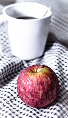 red apple and drink coffee cup on fabricの写真素材