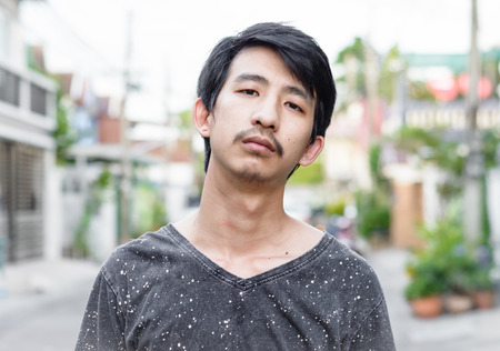 young asian man at sunrise evening on outdoor blur backgroundの写真素材