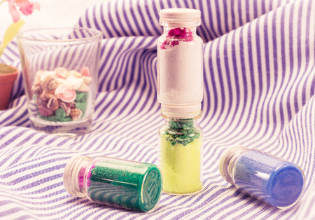 lovely decoration sand in bottle with retro filter on fabric pattern background