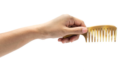 girl hand holding small plastic comb isolated on white backgroundの写真素材