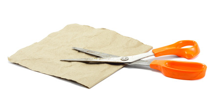 old orange color Scissors and brown paper isolated on white backgroundの写真素材