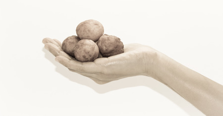 asian woman hand hold dounut ball bread with retro filter on white pattern background.の写真素材