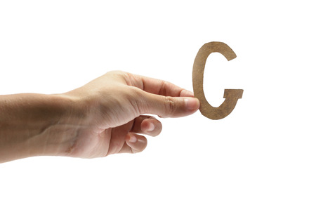 woman hand holding the brown letter g, isolated on white backgroundの写真素材