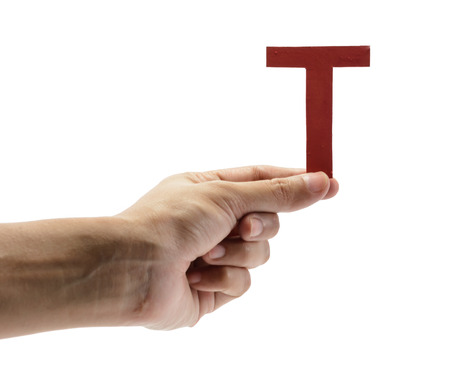 woman hand holding the red letter t, isolated on white backgroundの写真素材