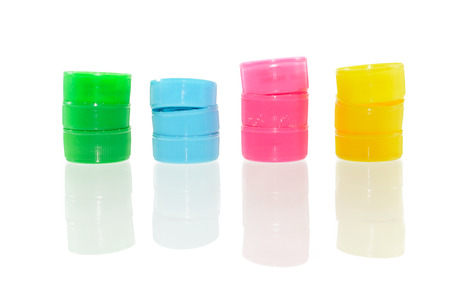 lot of colorful Plastic bottle screw caps with shadow reflection isolated on white background