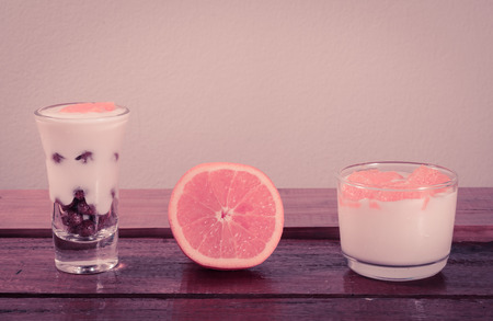 dessert Yogurt choco cereal and fresh orange on wooden table with retro filterの写真素材