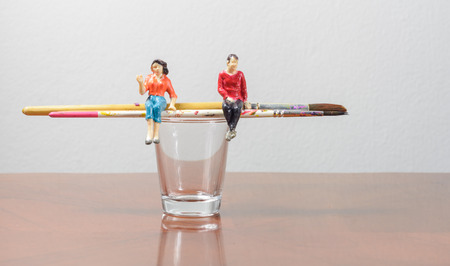 Miniature people sitting on paint brush concept art painting toolの写真素材