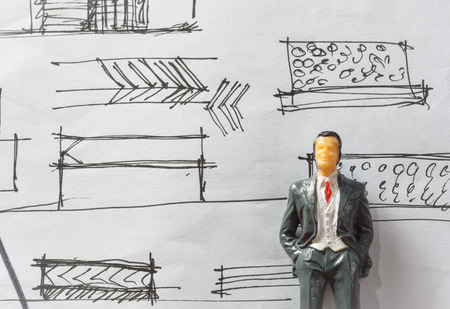 Miniature of businessman with sketch work paper concept about work   furniture