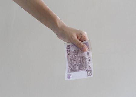 woman Hand holding korean money won on wall background
