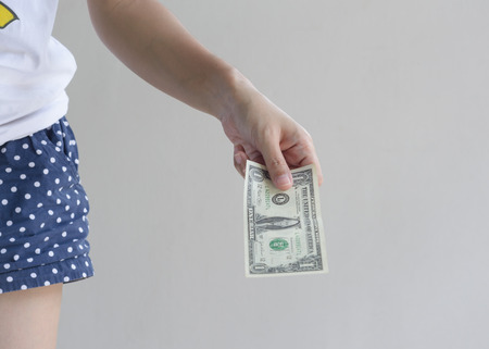 Female hands holding dollar money on wall 