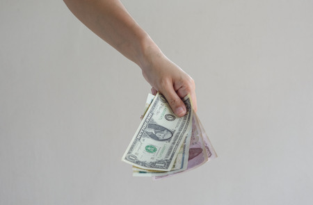 Female hands holding dollar and other banknotesの写真素材