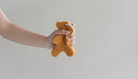sponge bath in a woman hand on a wall 