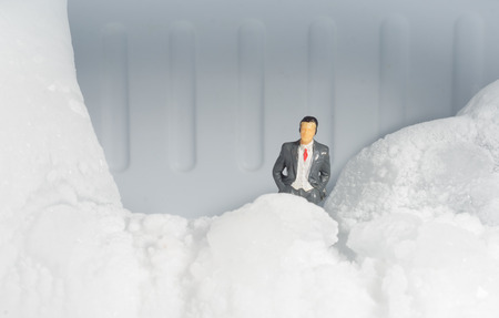 Miniature toy businessman work with small stone ice