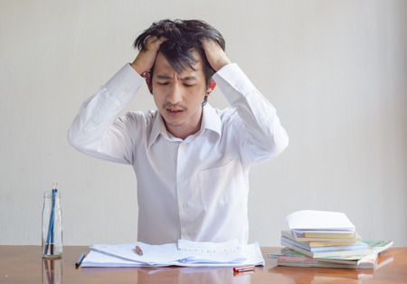 asian man angry with working on paper sheet and bookの写真素材