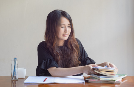 asian woman is working and reading a bookの写真素材