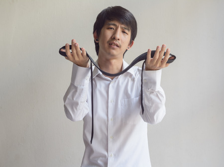 asia businessman adjusts a tie against on concrete wallの写真素材