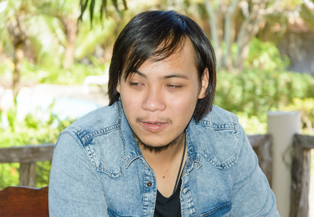 young asia man feel blur on outdoor natural backgroundの写真素材