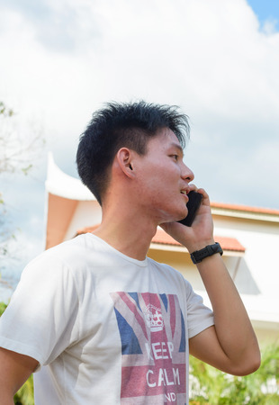 Man talk by smartphone on summer outdoorの写真素材