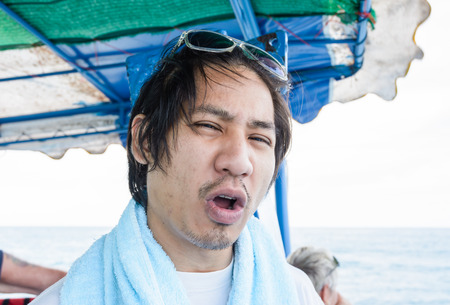 portrait asia man  relax and talking on the boat at sea
