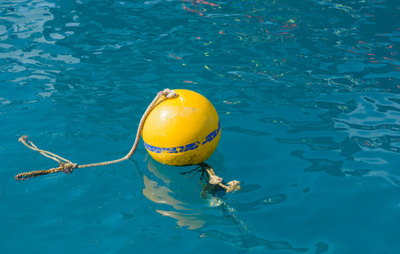 old yellow buoy in the natural sea