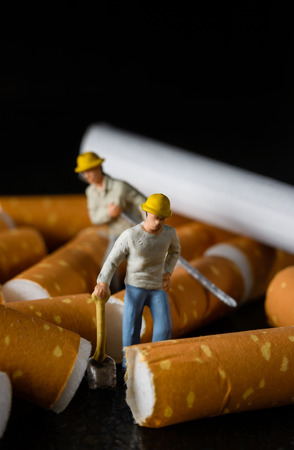 close up miniatures workers and cigarette butt patternの写真素材