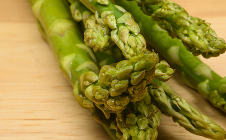 Close up of fresh green vegetable asparagus on woodの写真素材