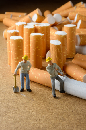 cigarette butt and man miniatures workers with select focusの写真素材