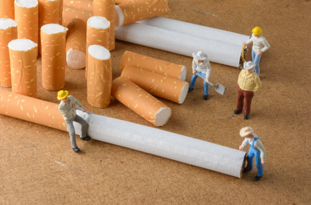 cigarette butt and man miniatures workers with select focusの写真素材