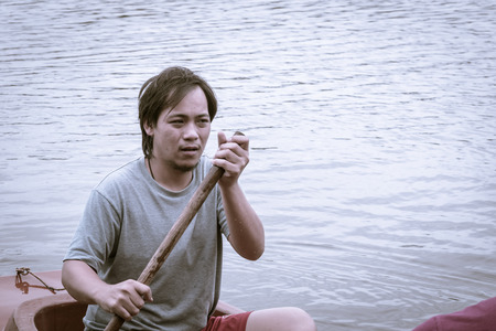 asia man driving with kayak on natural river (water sport) with retro filter