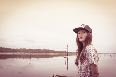 relaxing young asia woman near river water nature outdoor with retro filterの写真素材