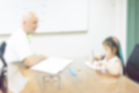 blurred background of child learning education in class room with teacherの写真素材