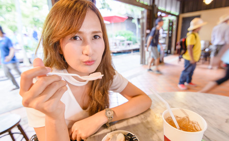 portrait asia Beautiful girl eat dessert and sitting in cafe.