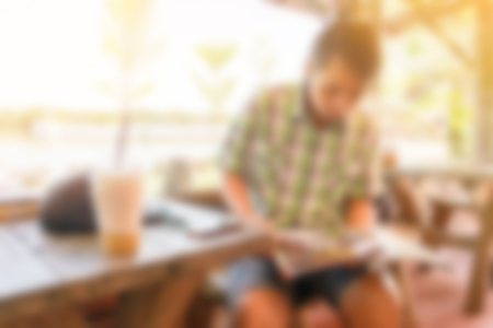 blur background of man relaxing and read book in coffee bar shopの写真素材